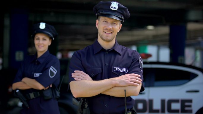 警官微笑着站在警察局附近