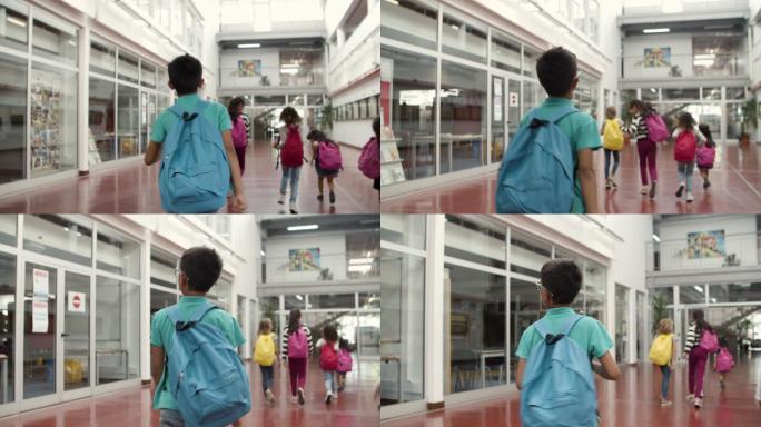 男孩在学校里走在同学后面的中镜头。
