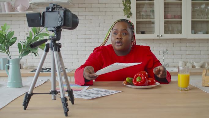 女性食品博主在厨房录制视频日志