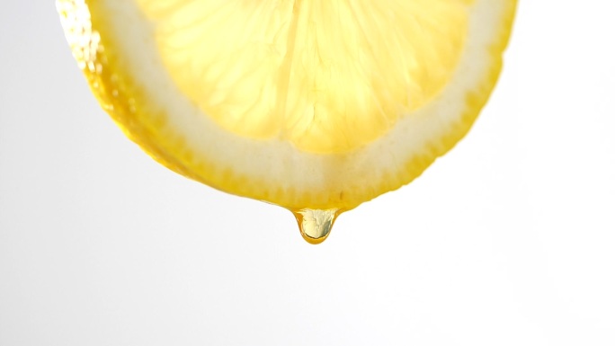 蜂蜜以慢动作从柠檬片上滴下