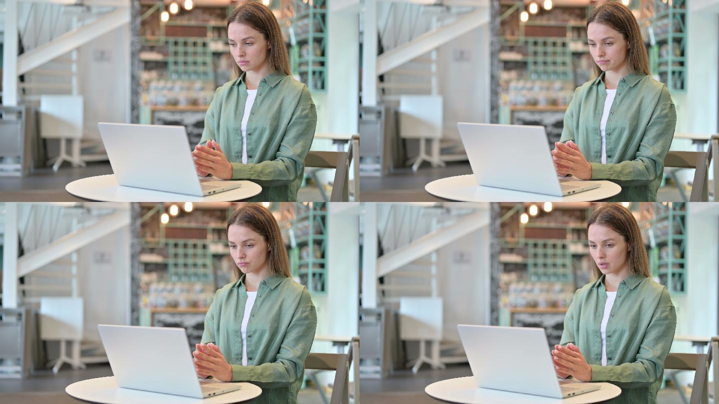 在咖啡馆用电脑思考和工作的女人