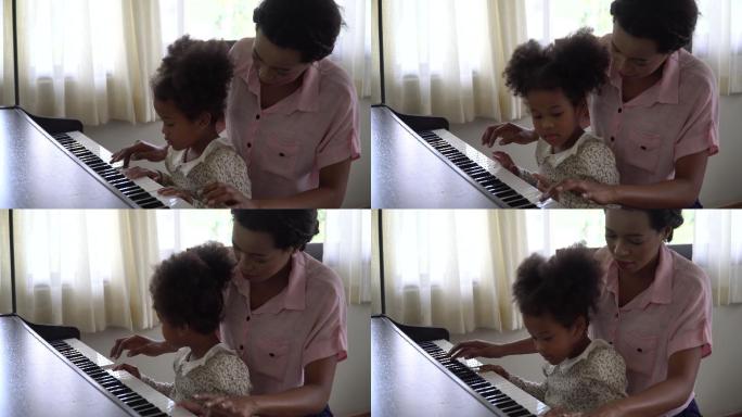 母亲教女儿在家里弹钢琴。