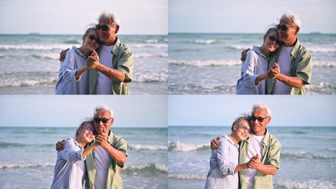 老年夫妇在海滩上拥抱着跳舞