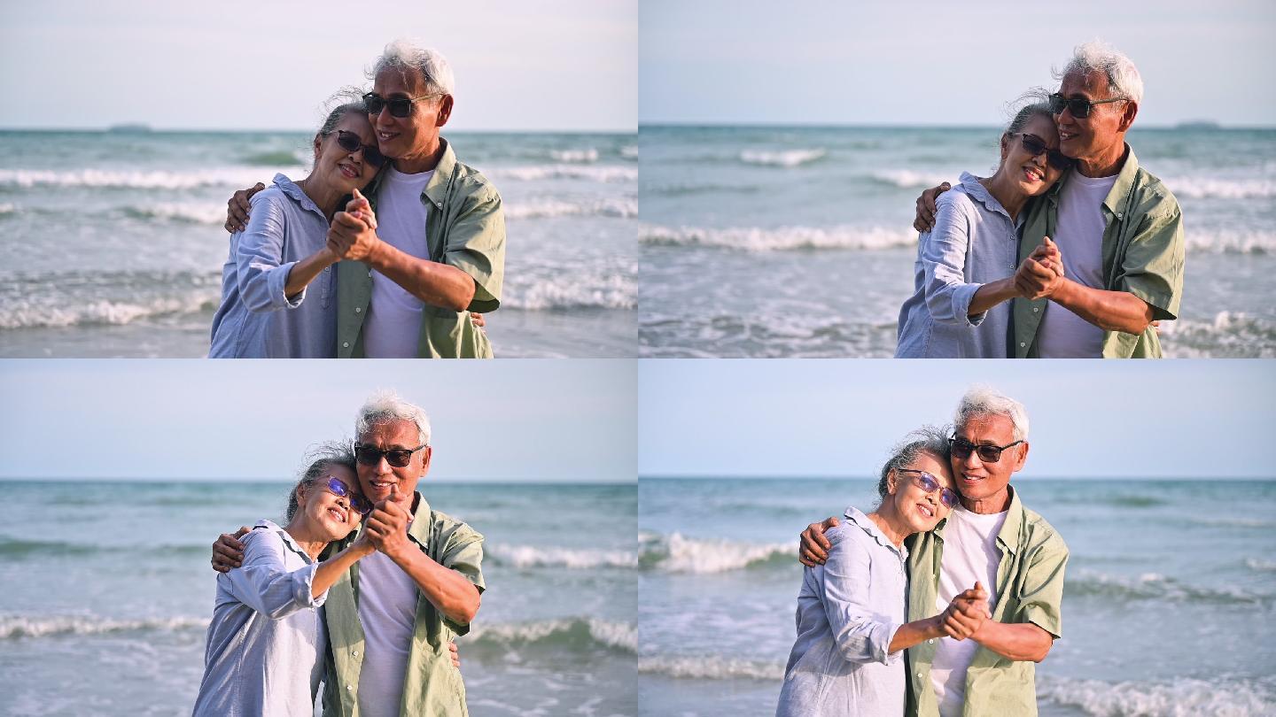 老年夫妇在海滩上拥抱着跳舞