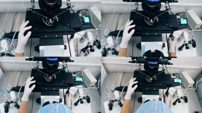 实验室工作人员正在调节显微镜