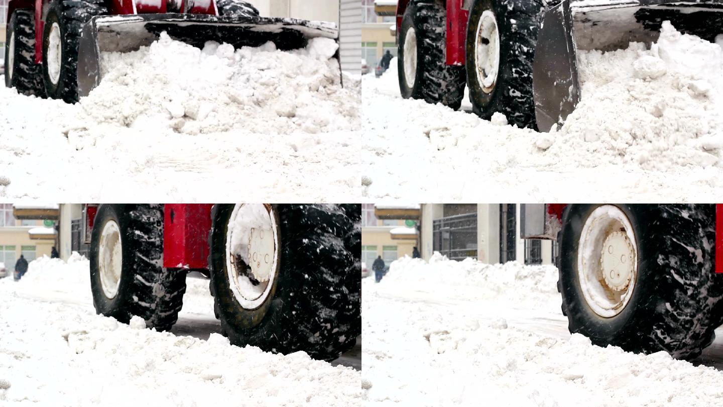 轮式装载机的铲斗铲走街道上的积雪