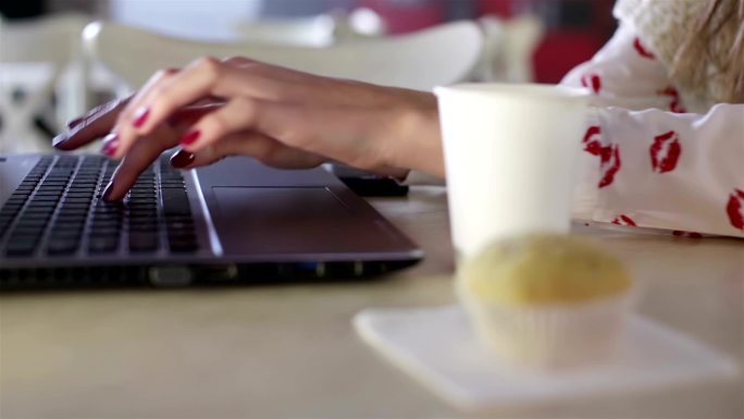 在咖啡馆用笔记本电脑工作的女孩