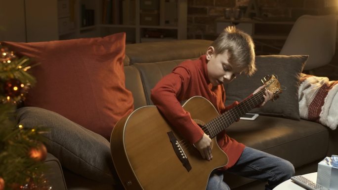 在弹吉他的小男孩儿童小孩弹琴