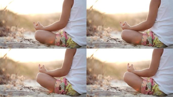 小女孩在日落时坐在沙滩上