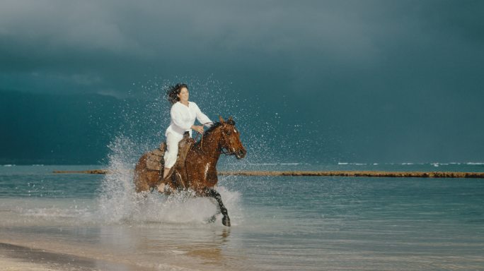 美丽的年轻女子在海滩上骑马