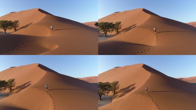 沙漠中行走的男人徒步探索孤独独行脚印