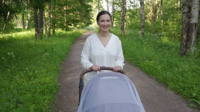 母亲推着婴儿车散步。