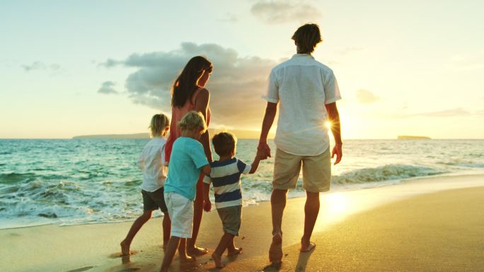 日落时海滩上的幸福家庭