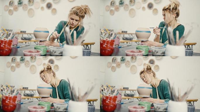 女人在艺术工作室用画笔画陶瓷壶