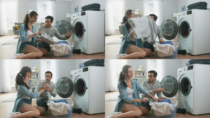 年轻夫妇坐在家里把脏衣服装进洗衣机里。