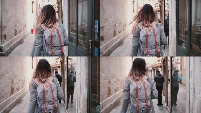 女游客在威尼斯的夏日老街漫步
