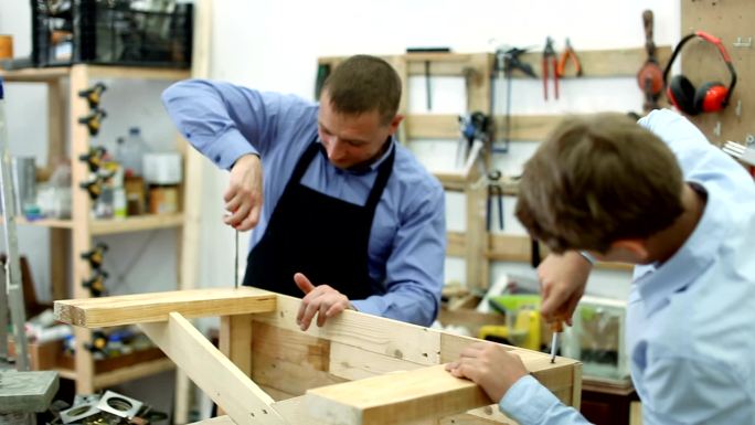 老师和男孩在制作木凳