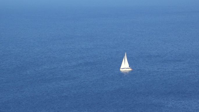 白色游船在无尽的蓝色海洋上航行