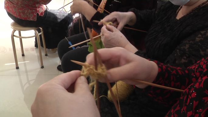 社区居民大妈在一起织毛衣交流经验