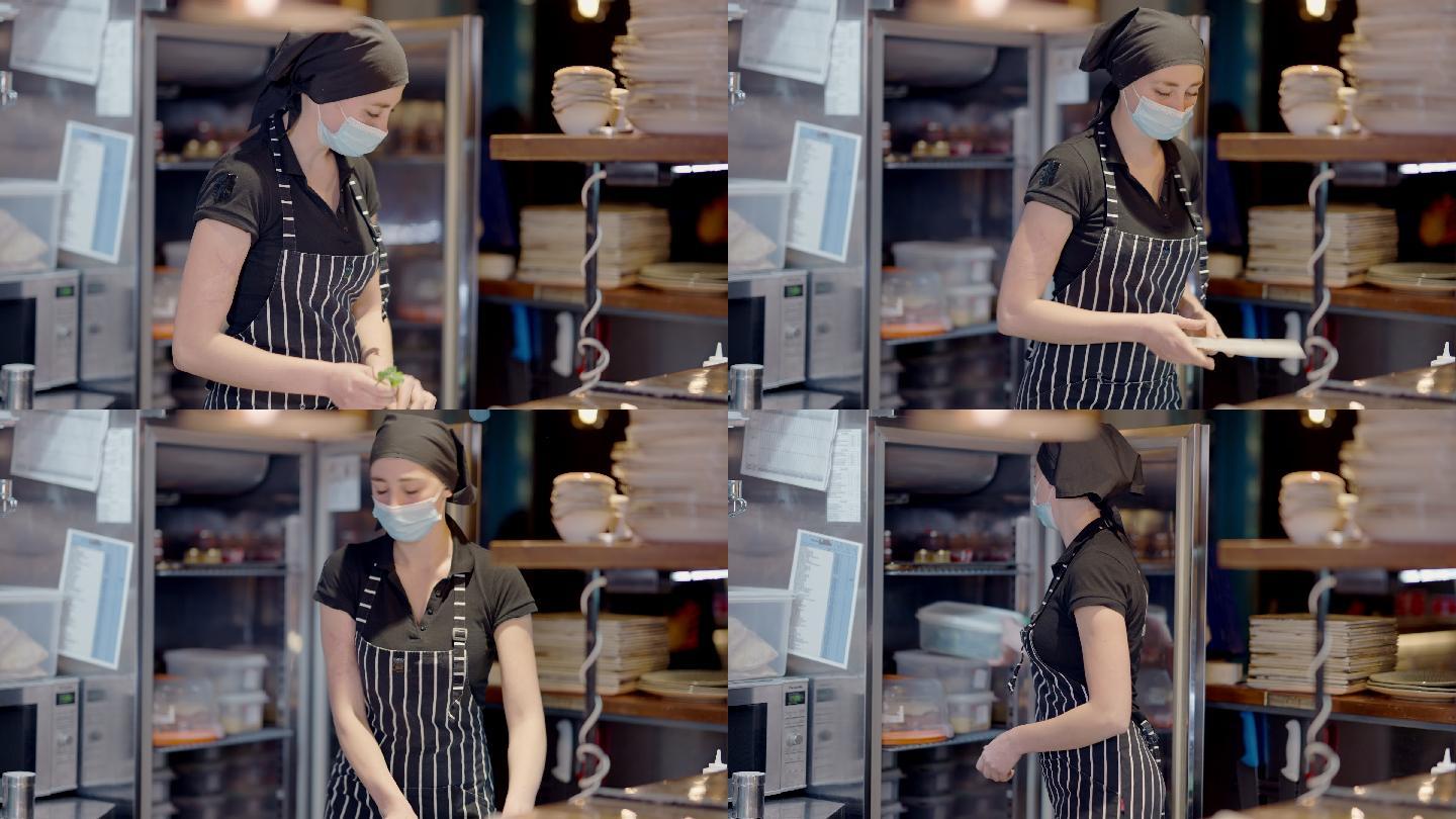 妇女戴口罩在厨房工作
