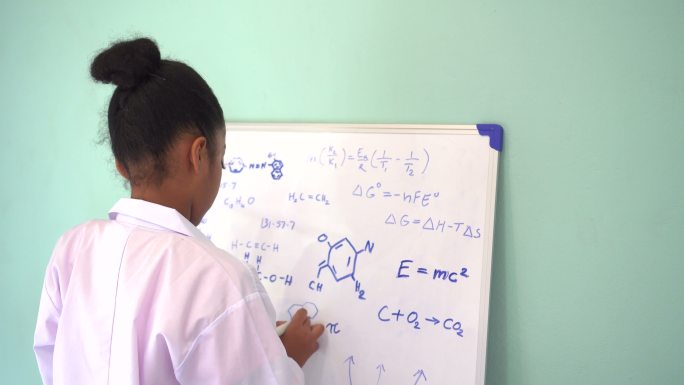女孩在白板上写数学和科学公式