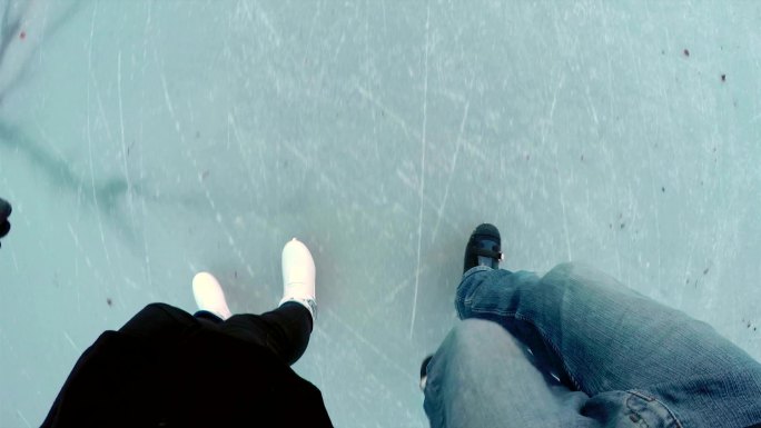 夫妇在冰冻的湖面上滑冰