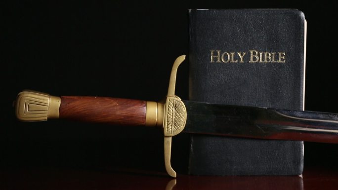 年轻人捡起圣经附近的剑