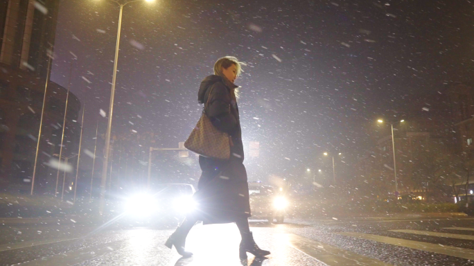 冬天夜晚大雪女生独自一人走在街道上