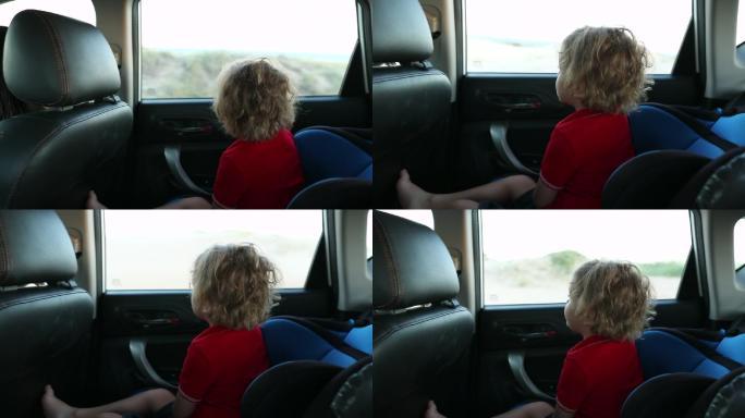 坐在汽车后座望着窗外的男孩