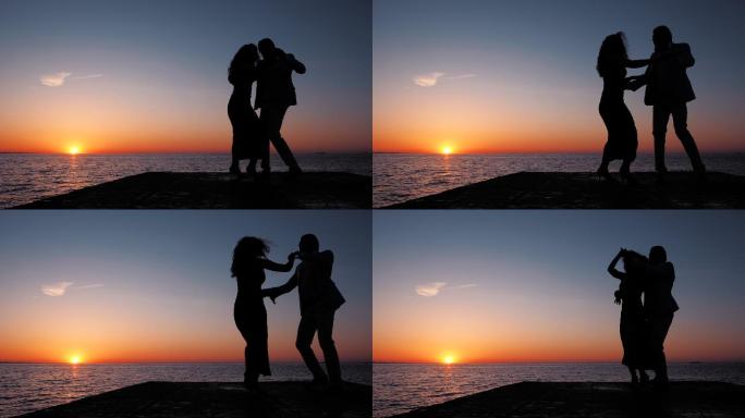 日落大海背景下年轻夫妇跳舞的剪影。