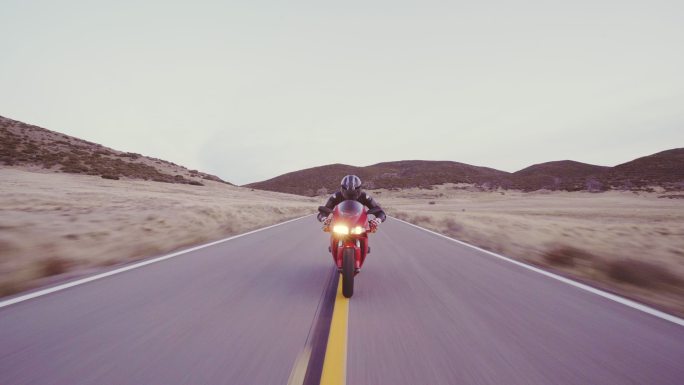 日落时骑摩托车的男子