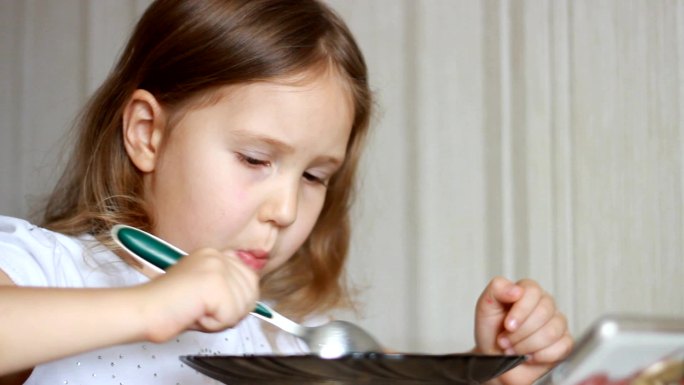 孩子用勺子吃饭可爱女孩吃饭