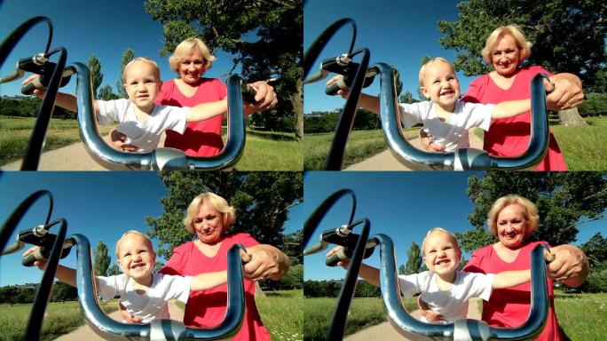 微笑的祖母和她的孙子在公园里骑自行车