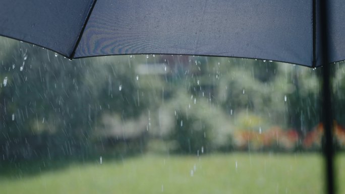 下雨时水滴从灰色伞的表面流下来