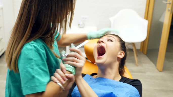 牙医准备给女子麻醉，病人被大针吓坏了