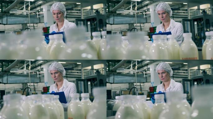 一名女员工正在食品厂检查乳制品生产过程。