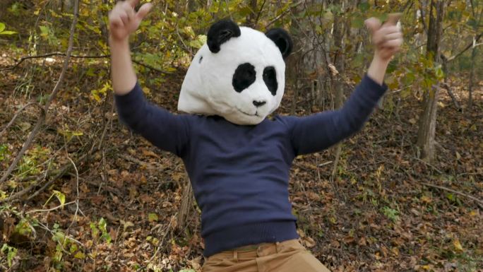 戴着熊猫面具庆祝胜利并跳舞的男子