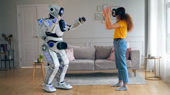 机器人模仿女人的动作，而她戴着VR眼镜。
