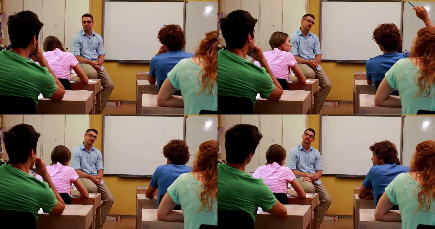 讲师在教室里坐着和他的学生说话