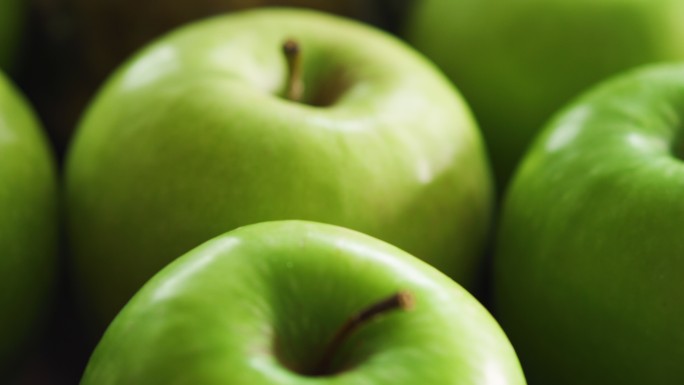 一组健康新鲜的绿色苹果中的腐烂苹果。