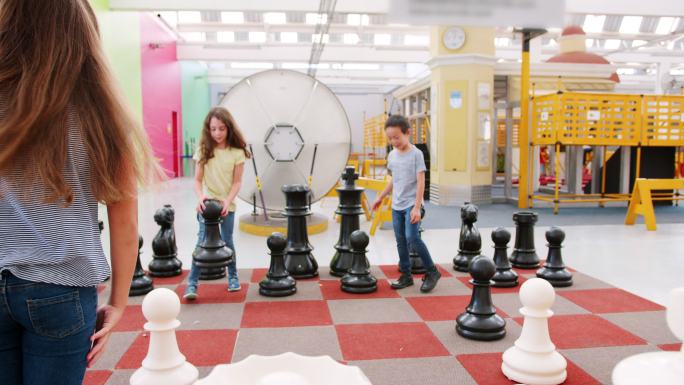 四个孩子在一个科学活动中心下棋