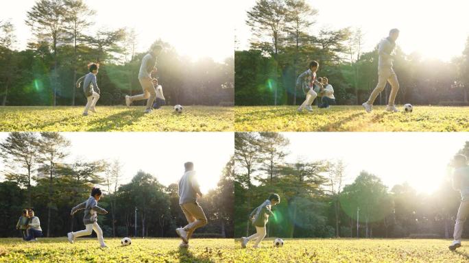亚洲小男孩和爸爸在公园外面踢足球