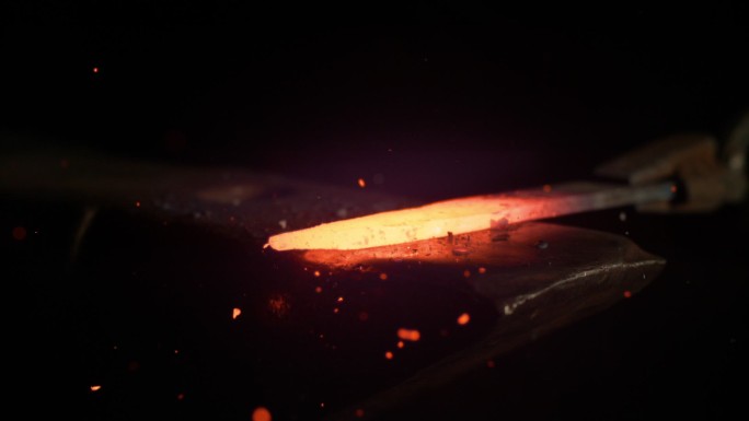 一块发光的铁被锻造成刀刃。