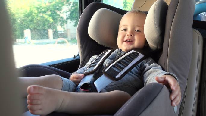 小婴儿安静地坐在汽车的安全座椅上。