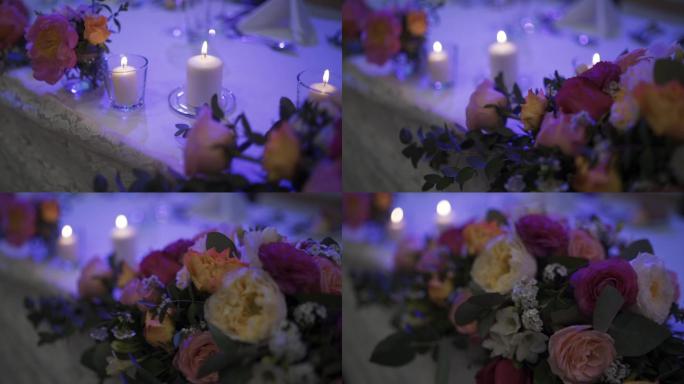 婚礼上摆满餐、花和蜡烛的大桌子的照片