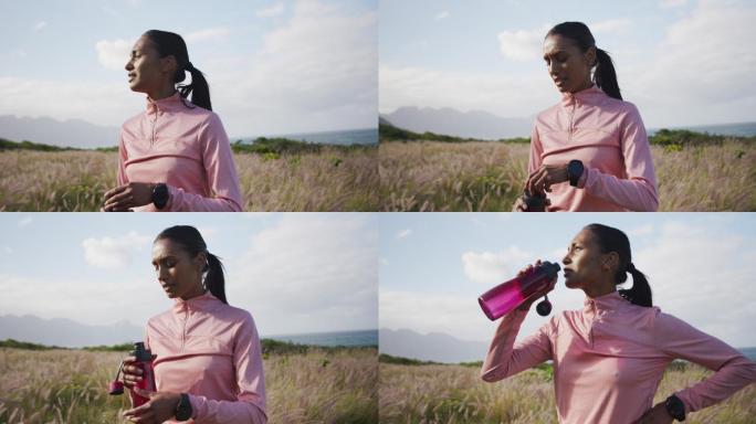 妇女在山区徒步旅行时饮用瓶装水