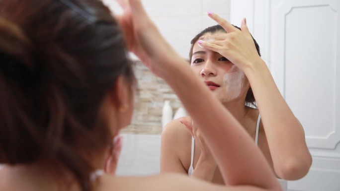 女人在浴室用肥皂清洁皮肤。