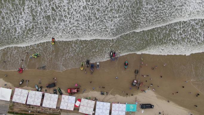 参加比赛的摩托艇停放在海边沙滩上繁忙景象