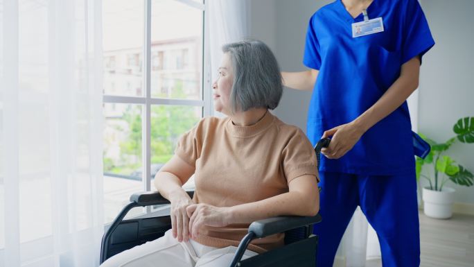 护士在养老院照顾坐轮椅的老年病人