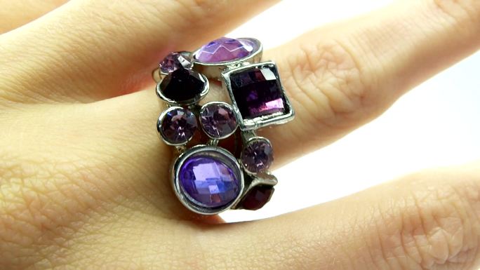 手指上镶有紫色水晶的珠宝戒指